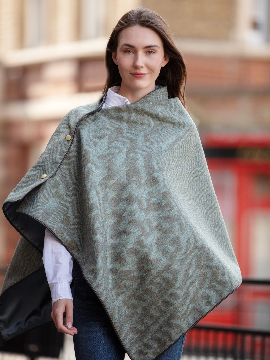Green herringbone tweed shawl with burgundy satin lining, gold studs, and dark brown faux leather trim, made in the UK by John Partridge.