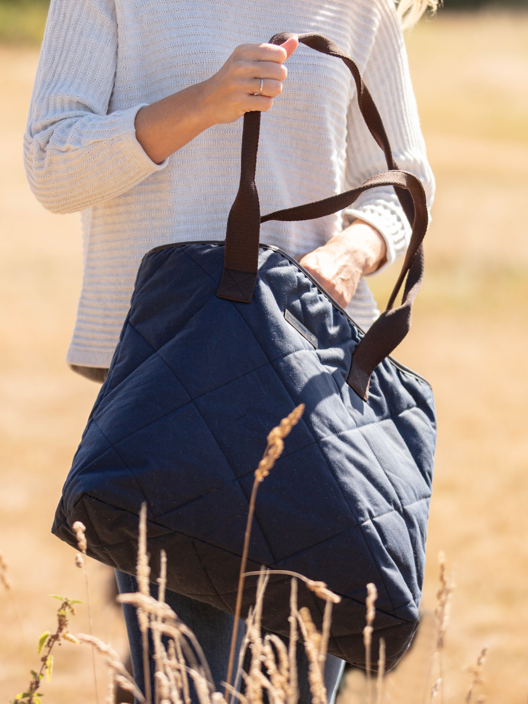 John Partridge & Co. Oversized Tote Bag in navy with herringbone straps, leather-look binding, antique brass plate, and spacious interior, expertly crafted in England.