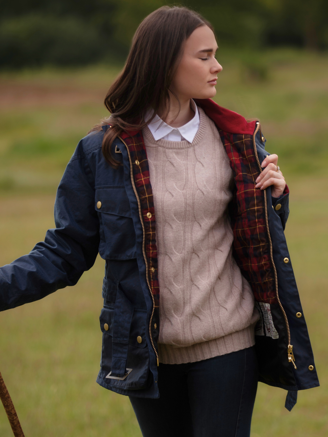 Wax Biker Jacket in Ocean Navy with cherry check lining, burgundy cotton moleskin collar, oversized pockets, and detachable belt. Crafted from British waxed material with tonal embroidery and gold-coloured studs for a blend of tradition, luxury, and modern function.