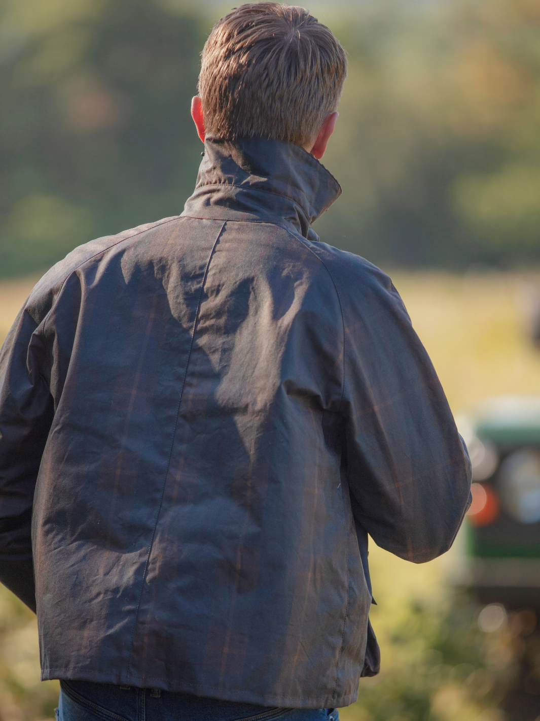 Landowner Short Wax Walking Jacket in Hunter Check with warm brown tones. A unisex, boxy-shaped waxed cotton jacket featuring cord and moleskin details for timeless elegance and weather protection, perfect for outdoor adventures or everyday wear.