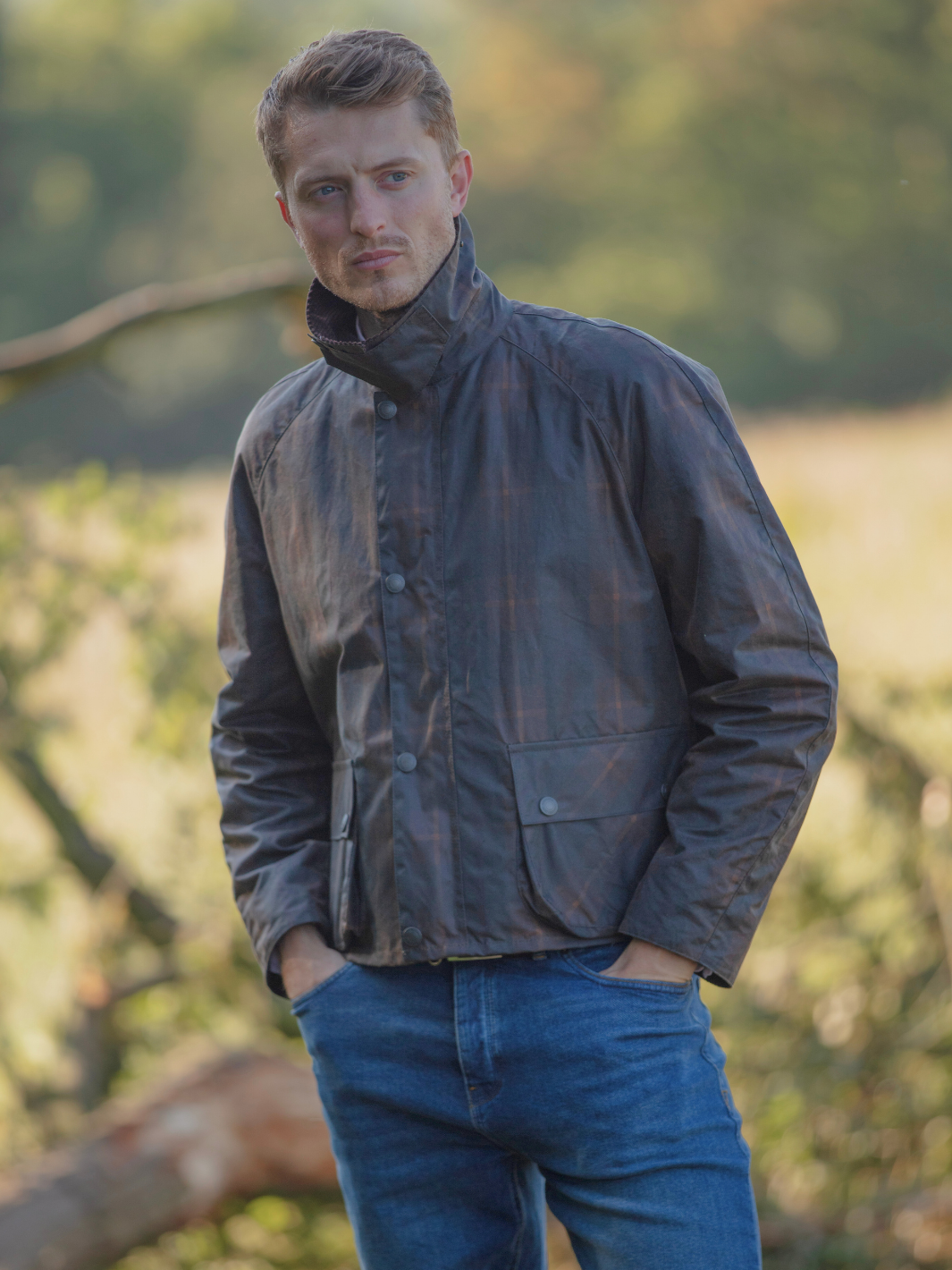 Landowner Short Wax Walking Jacket in Hunter Check with warm brown tones. A unisex, boxy-shaped waxed cotton jacket featuring cord and moleskin details for timeless elegance and weather protection, perfect for outdoor adventures or everyday wear.