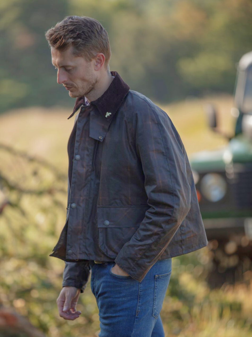 Landowner Short Wax Walking Jacket in Hunter Check with warm brown tones. A unisex, boxy-shaped waxed cotton jacket featuring cord and moleskin details for timeless elegance and weather protection, perfect for outdoor adventures or everyday wear.