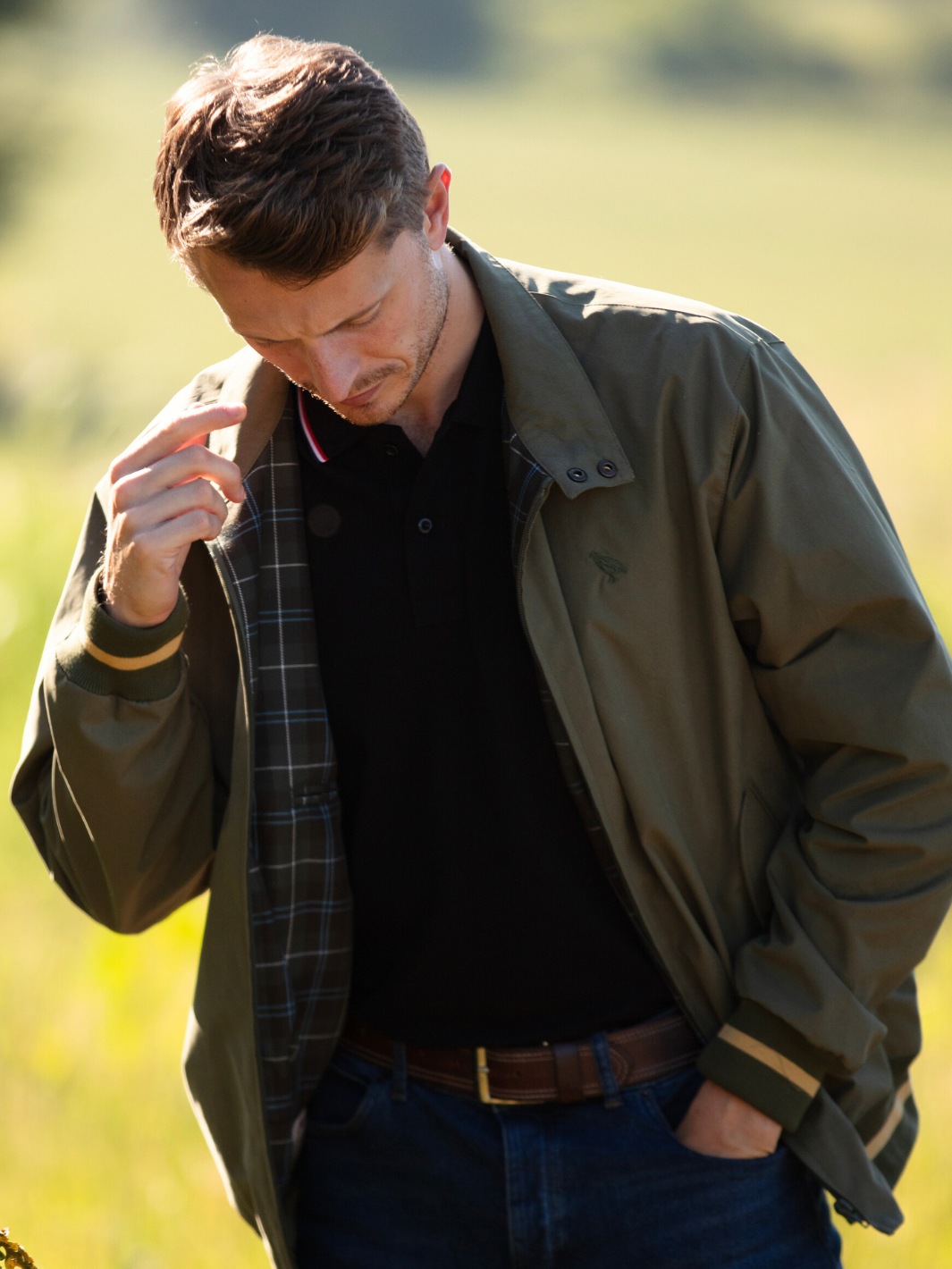 Men's Harrington Jacket in olive green with zip front fastening, two front pockets, and olive check lining. Crafted in England with tonal green Partridge bird embroidery, combining timeless style, practicality, and superior craftsmanship.