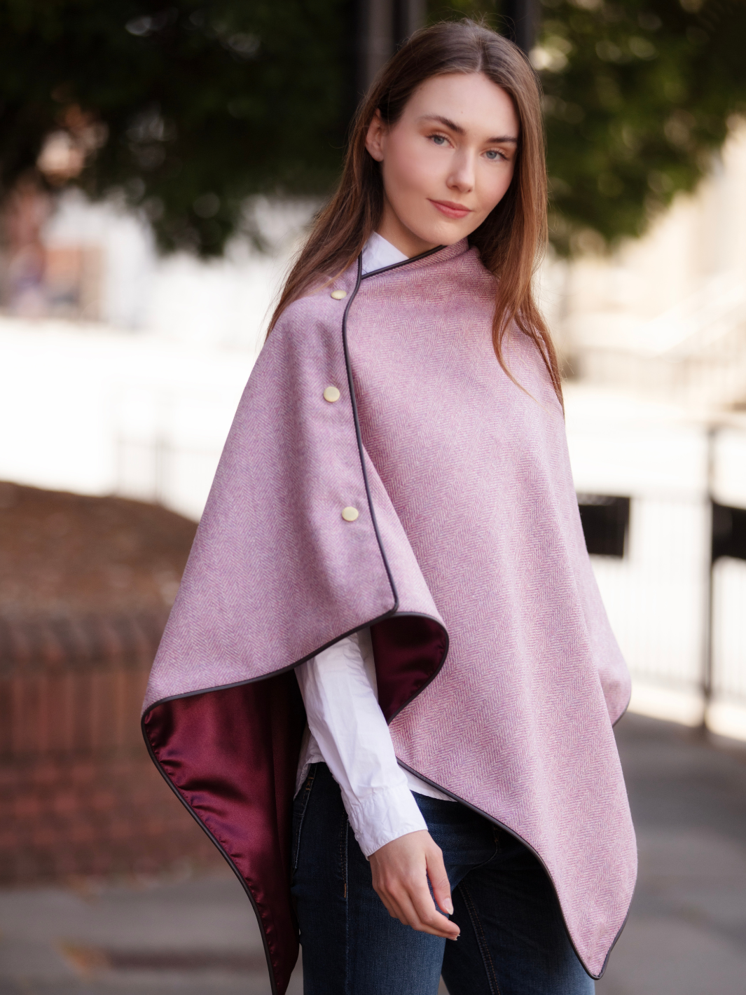 Soft pink herringbone tweed shawl with burgundy satin lining, gold studs, and dark brown faux leather trim, made in the UK by John Partridge.