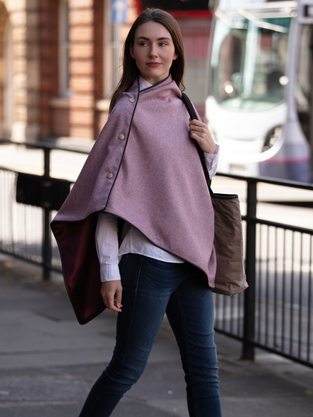Soft pink herringbone tweed shawl with burgundy satin lining, gold studs, and dark brown faux leather trim, made in the UK by John Partridge.