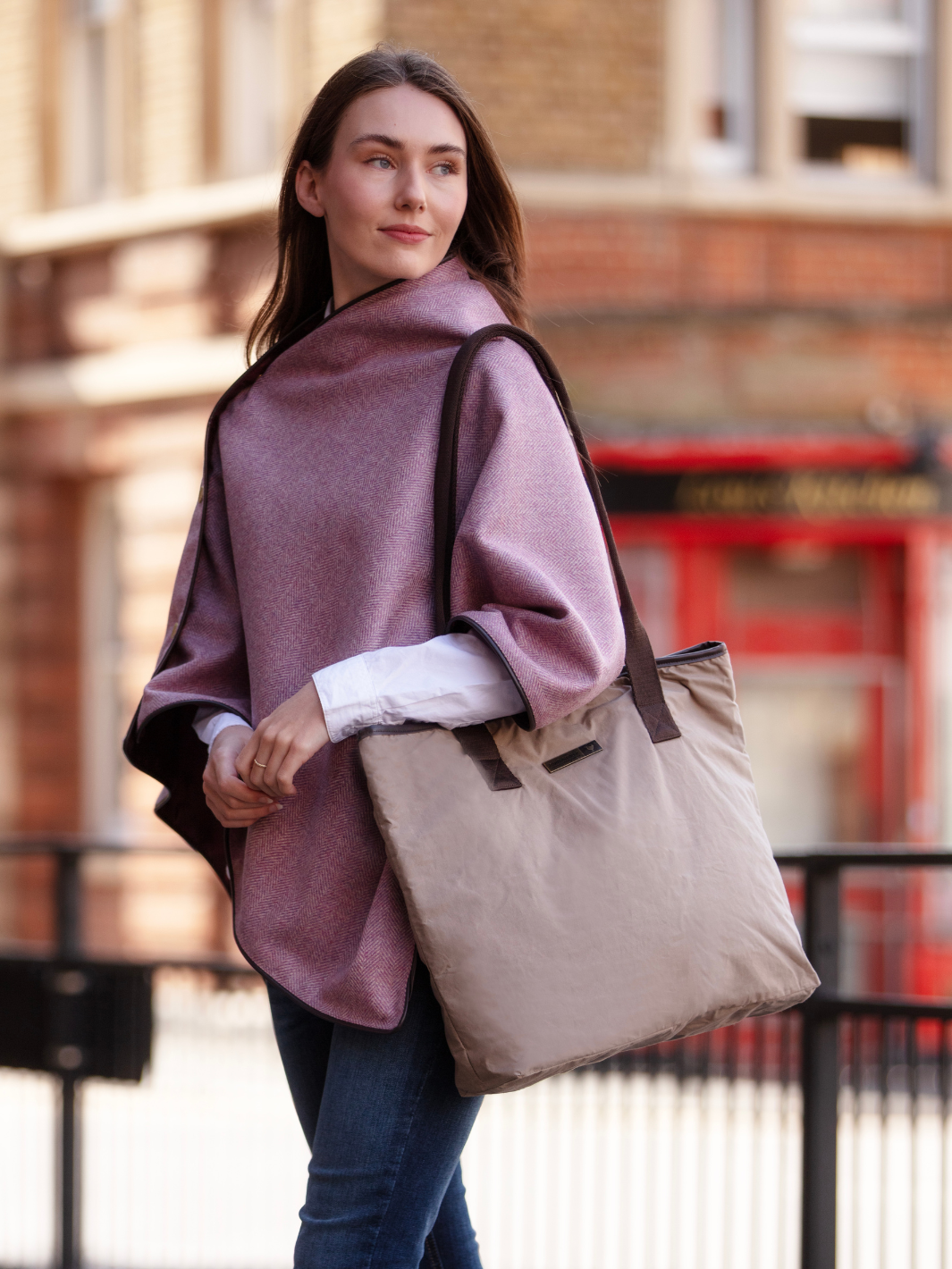 Soft pink herringbone tweed shawl with burgundy satin lining, gold studs, and dark brown faux leather trim, made in the UK by John Partridge.