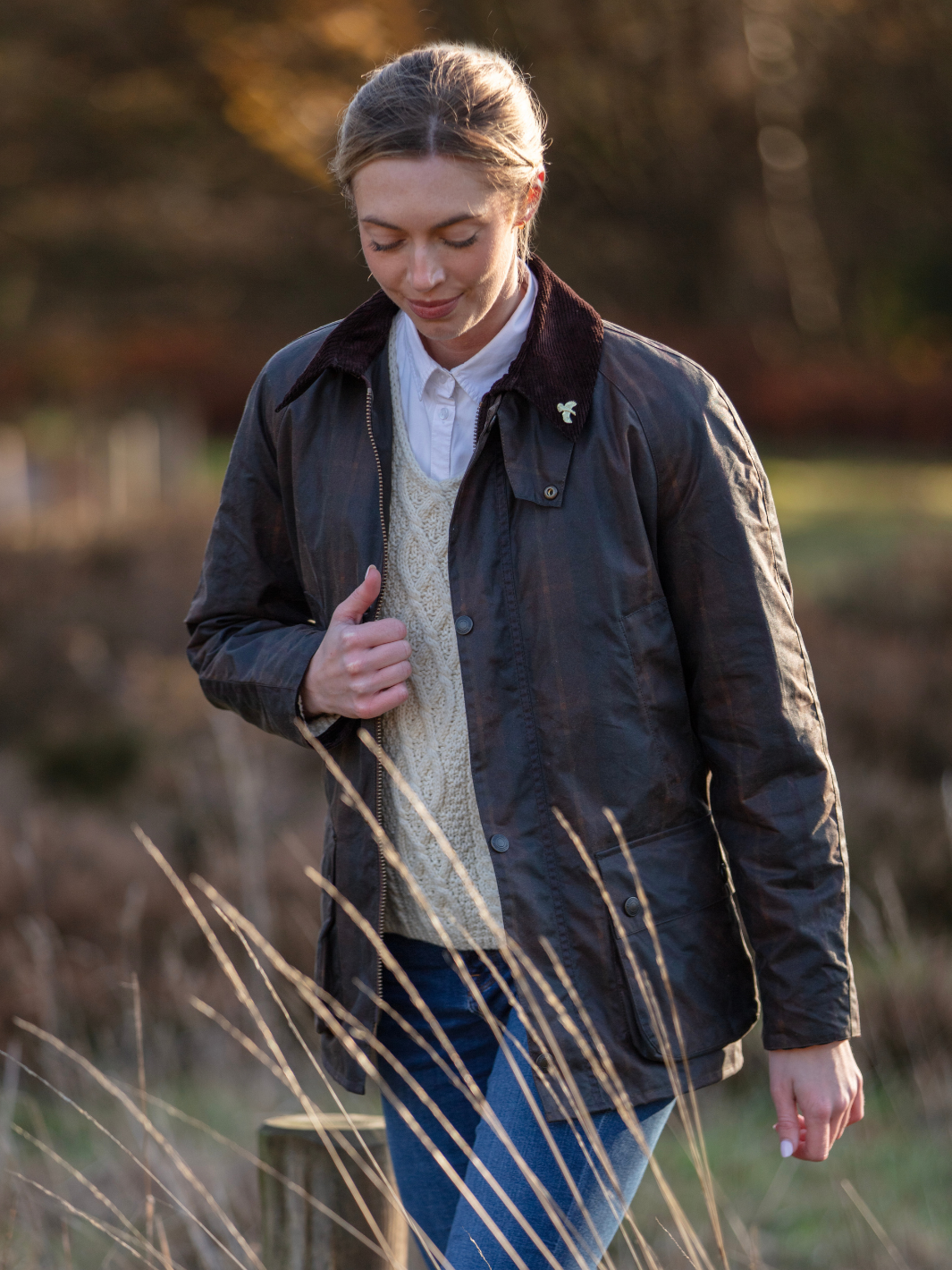 Women’s Waxed Country Jacket | Dark brown wax jacket with cord collar, cream cable knit jumper, white shirt and blue jeans
