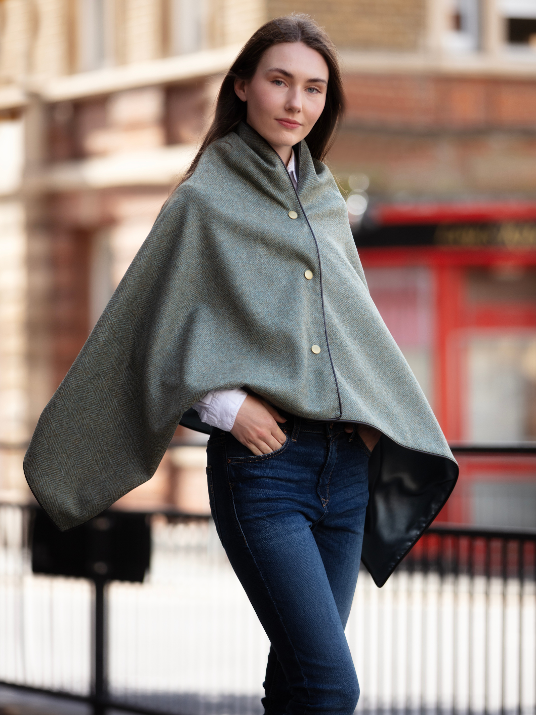 Green herringbone tweed shawl with burgundy satin lining, gold studs, and dark brown faux leather trim, made in the UK by John Partridge.