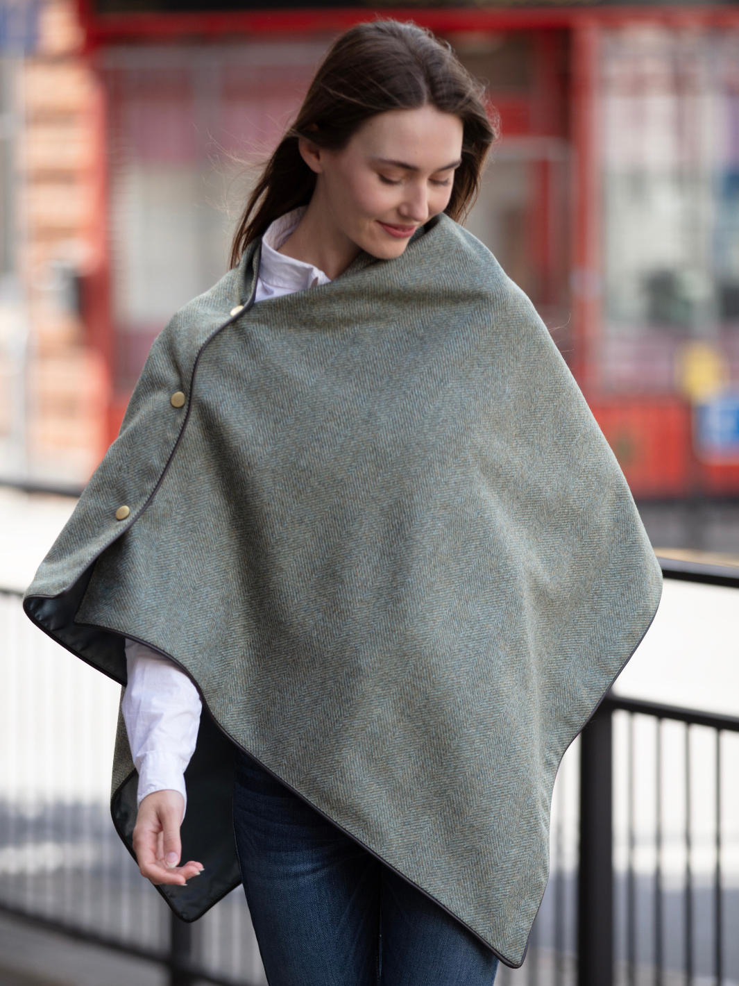 Green herringbone tweed shawl with burgundy satin lining, gold studs, and dark brown faux leather trim, made in the UK by John Partridge.