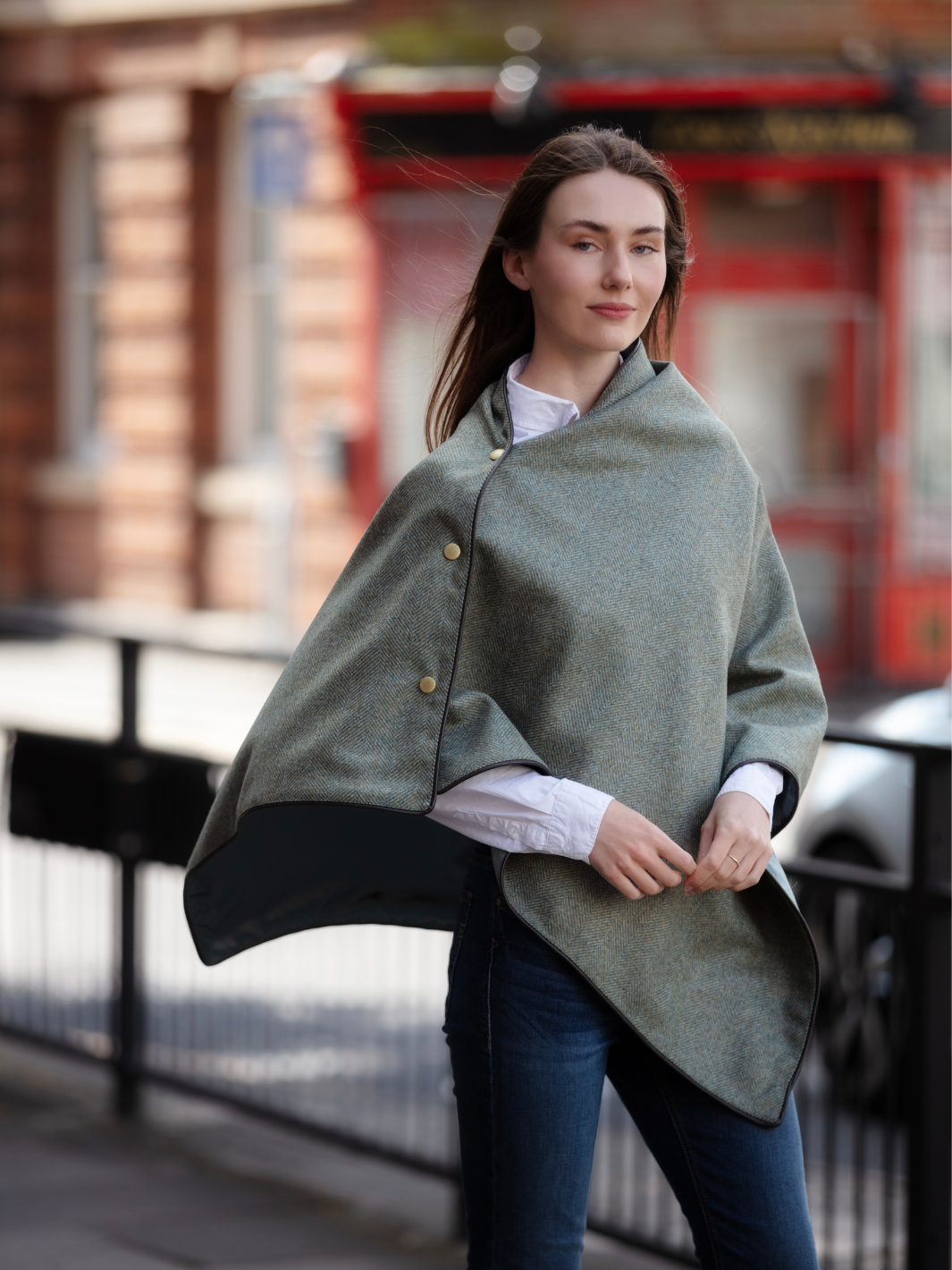 Green herringbone tweed shawl with burgundy satin lining, gold studs, and dark brown faux leather trim, made in the UK by John Partridge.