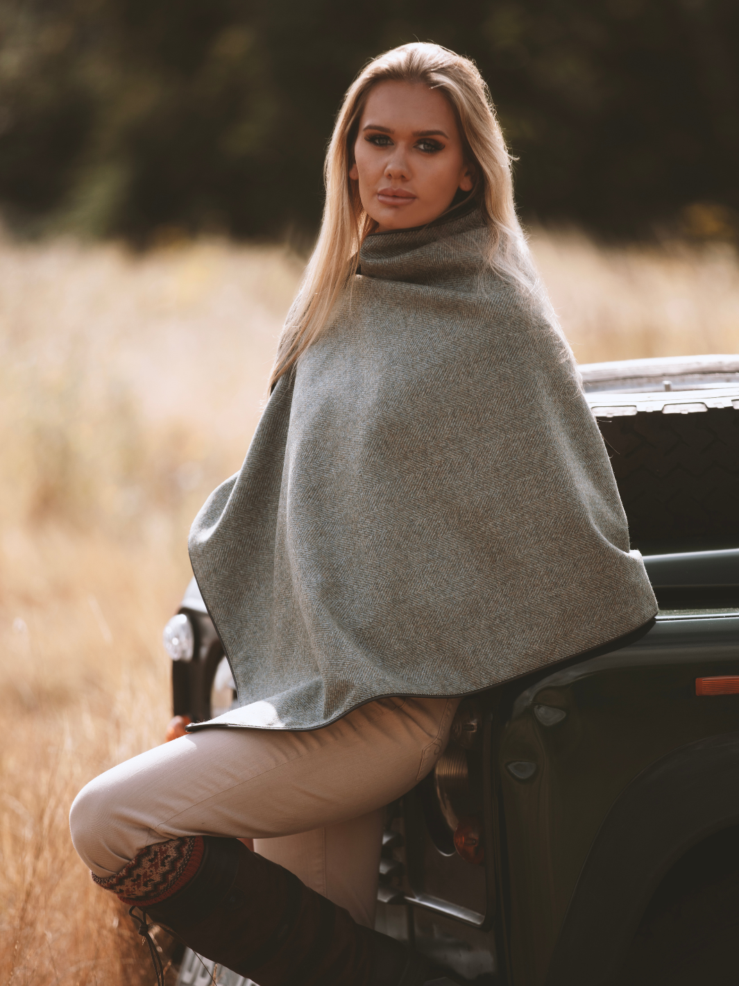 Green herringbone tweed shawl with burgundy satin lining, gold studs, and dark brown faux leather trim, made in the UK by John Partridge.