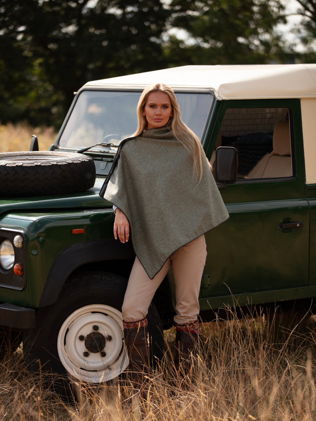 Green herringbone tweed shawl with burgundy satin lining, gold studs, and dark brown faux leather trim, made in the UK by John Partridge.