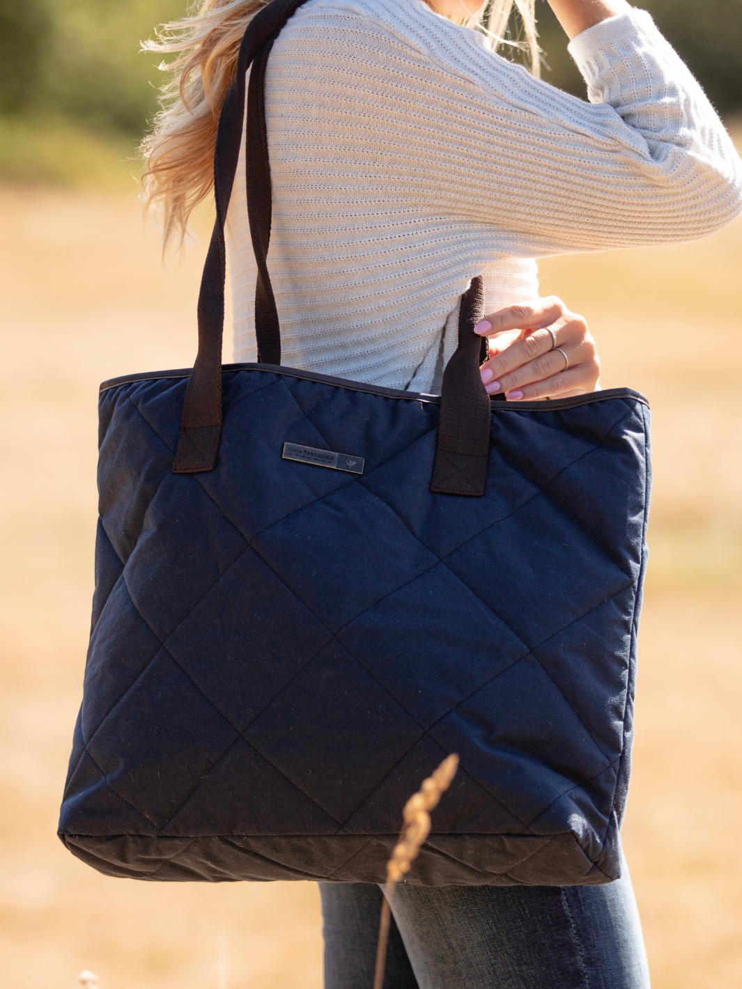 John Partridge & Co. Oversized Tote Bag in navy with herringbone straps, leather-look binding, antique brass plate, and spacious interior, expertly crafted in England.