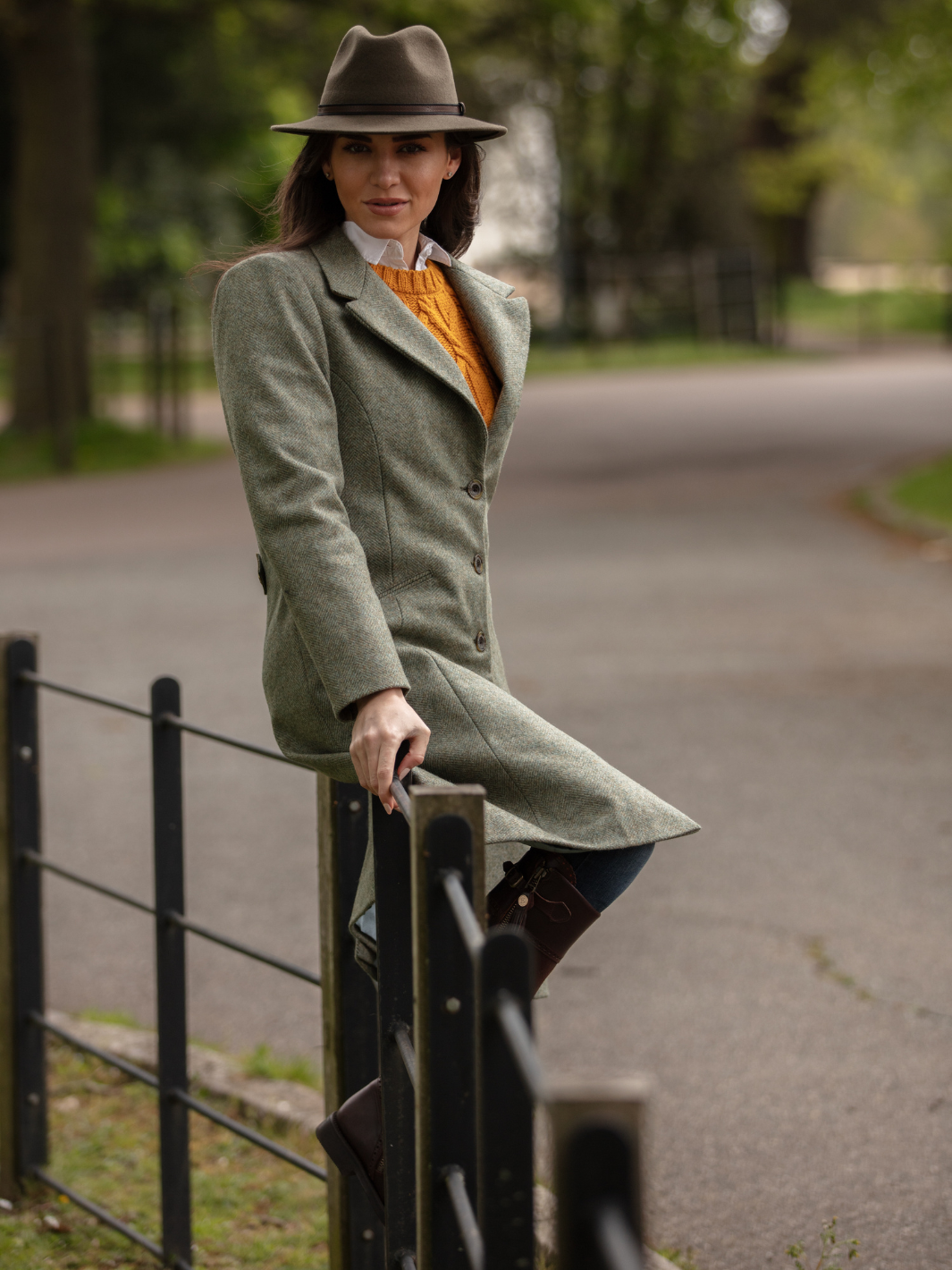 Lichfield Long Ladies' Tweed Coat in pastel green herringbone wool with John Partridge branded buttons, soft satin turquoise lining, forest green velvet cuffs and under collar, and reversible back belt. Features include 2 front pockets, back vent, and knee-length design. Available in pastel green, pink, and blue. Made in England.