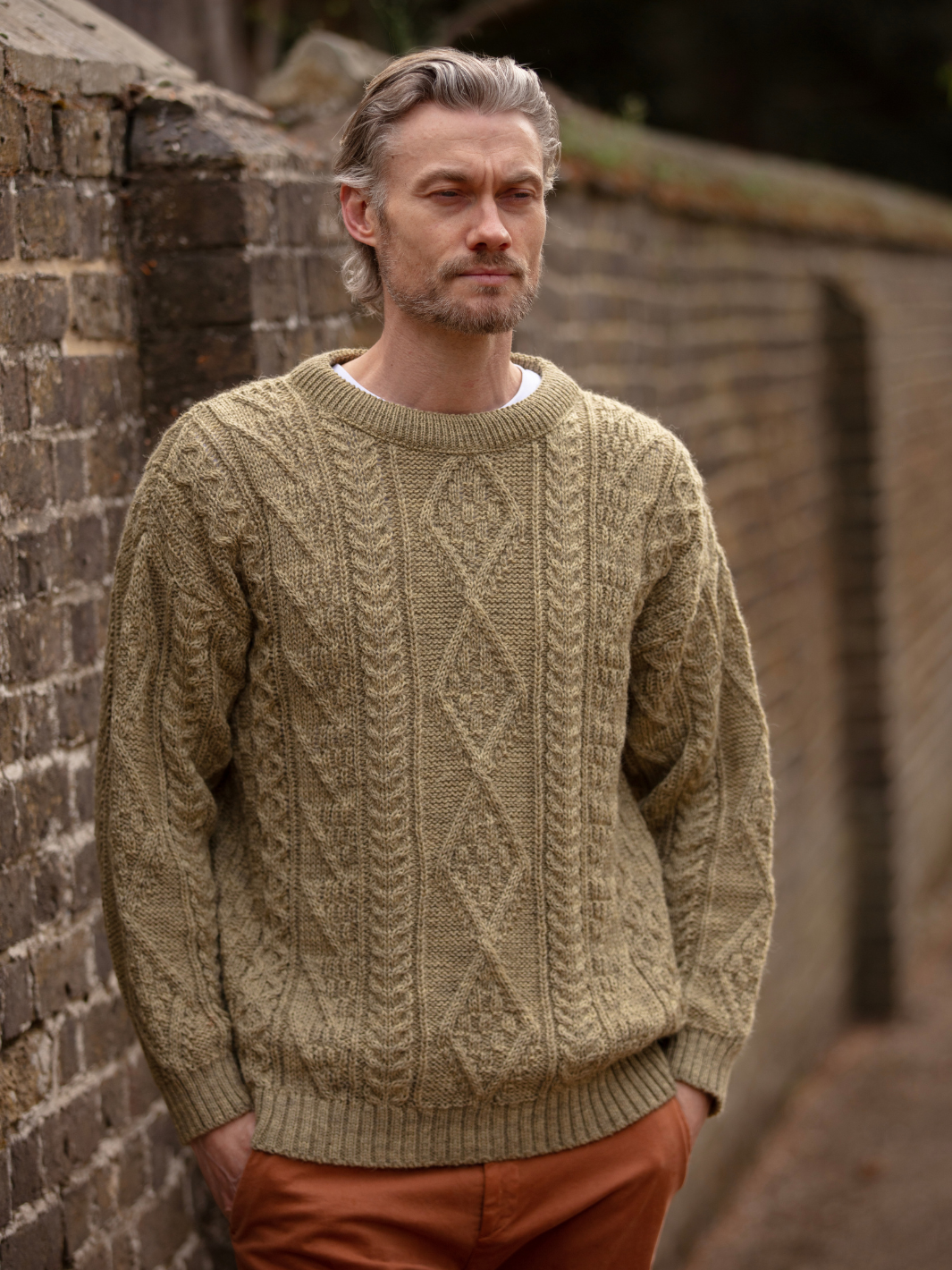 Unisex Aran Wool Jumper - Warm Stone | Men’s model wearing a breathable British wool jumper with classic textured stitching