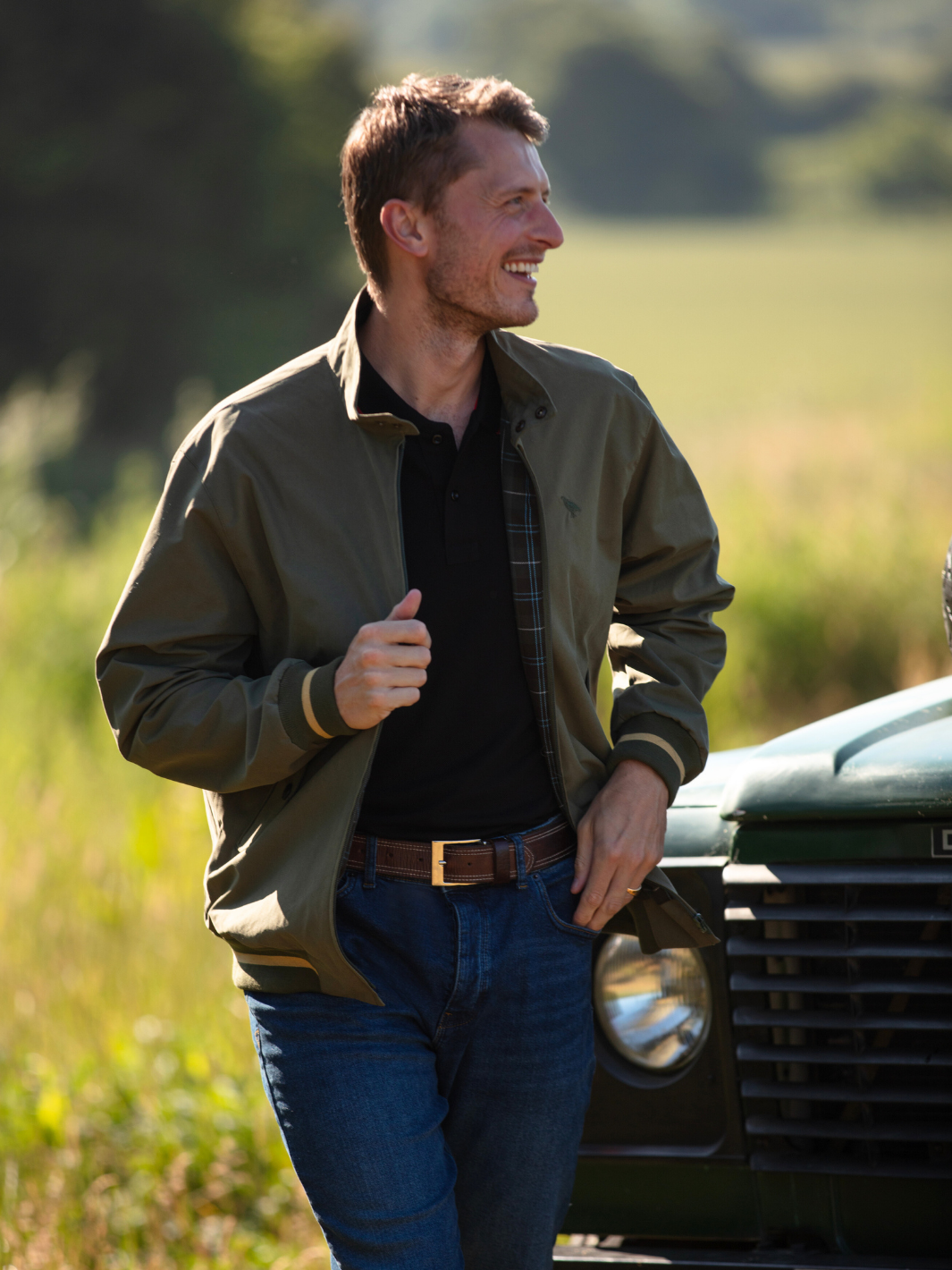 Men's Harrington Jacket in olive green with zip front fastening, two front pockets, and olive check lining. Crafted in England with tonal green Partridge bird embroidery, combining timeless style, practicality, and superior craftsmanship.